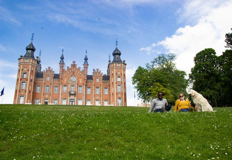 twee mensen met hond voor het kasteel