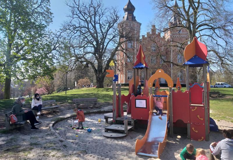 Kind op glijbaan met op achtergrond het kasteel