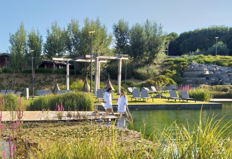 Twee dames bij vijver buiten met terrasmeubelen