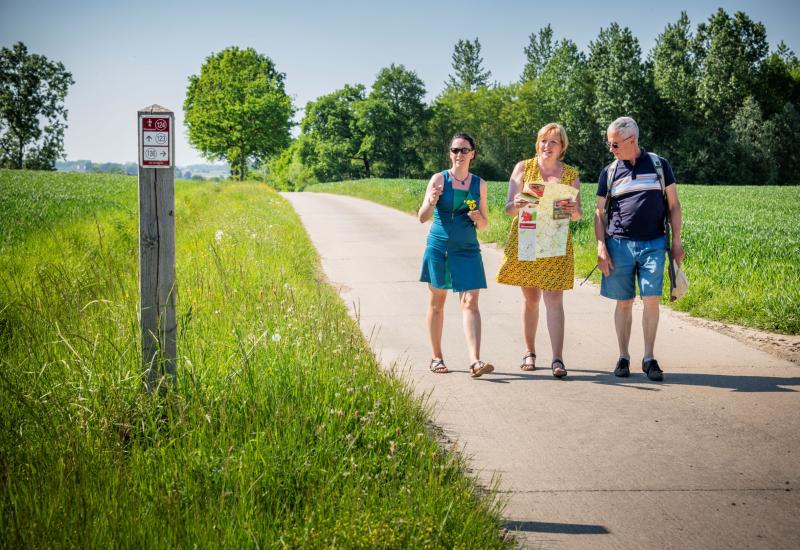 wandelaars met kaart en een knooppuntenbordje